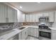Updated kitchen with white cabinets, marble countertops, tile backsplash, and stainless appliances at 513 Elm St, Boulder City, NV 89005