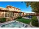 Well-maintained backyard with a hot tub, green lawn, patio area with seating, and manicured landscaping at 5741 Shadow Bend Dr, Las Vegas, NV 89135