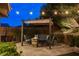 Cozy backyard patio with pergola, outdoor seating, and ambient string lights perfect for relaxing evenings at 5741 Shadow Bend Dr, Las Vegas, NV 89135
