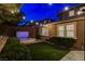 Night view of backyard featuring a hot tub, artificial grass, lush landscaping and covered patio at 5741 Shadow Bend Dr, Las Vegas, NV 89135