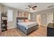 Comfortable bedroom featuring a tufted headboard, wood-look floors, and a ceiling fan for added comfort at 5741 Shadow Bend Dr, Las Vegas, NV 89135
