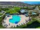 Aerial view of the Community pool with lounge chairs, tables, and umbrellas surrounded by neighborhood homes at 5741 Shadow Bend Dr, Las Vegas, NV 89135