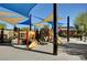 Community playground featuring slides and climbing structures, shaded by colorful awnings for sun protection at 5741 Shadow Bend Dr, Las Vegas, NV 89135