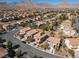 Wide angle aerial view of the neighborhood, lush trees, desert landscaping and mountain views at 575 Lacabana Beach Dr, Las Vegas, NV 89138