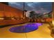 Stunning backyard pool with illuminated landscaping, lounge chairs, and decorative egg chair at 575 Lacabana Beach Dr, Las Vegas, NV 89138