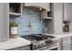 Modern kitchen features updated appliances, gray cabinets and a stylish blue tile backsplash at 575 Lacabana Beach Dr, Las Vegas, NV 89138