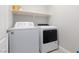 Well-lit laundry room showcasing modern washer and dryer units with an above shelf at 575 Lacabana Beach Dr, Las Vegas, NV 89138