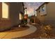 Serene side yard with a curved walkway, manicured landscaping, and ambient lighting at 575 Lacabana Beach Dr, Las Vegas, NV 89138