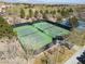 Aerial view of fenced tennis courts, set amongst lush trees in a well-maintained sports facility at 575 Lacabana Beach Dr, Las Vegas, NV 89138