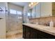 Elegant bathroom with a glass enclosed shower, double sinks, dark wood cabinets and marble countertops at 6686 Enchanted Cove Ct, Las Vegas, NV 89139