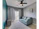 Bright bedroom featuring plush carpet, modern ceiling fan, couch, and sliding door to a small balcony at 6686 Enchanted Cove Ct, Las Vegas, NV 89139