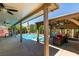 Beautiful pool with a covered patio, comfortable seating and meticulous landscaping creating a tranquil escape at 6686 Enchanted Cove Ct, Las Vegas, NV 89139