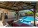 Relaxing backyard pool area with a covered patio and an outdoor kitchen, perfect for entertaining guests at 6686 Enchanted Cove Ct, Las Vegas, NV 89139
