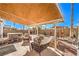 Inviting backyard featuring hot tub, shade structure, lounging furniture, and stone at 7267 Sequoia Springs Dr, Las Vegas, NV 89147