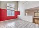Bright living room with tile flooring, a large window, and a contrasting red accent wall, with an open floor plan at 7267 Sequoia Springs Dr, Las Vegas, NV 89147