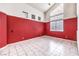 Spacious living room with tile flooring, a large window, and a contrasting red accent wall at 7267 Sequoia Springs Dr, Las Vegas, NV 89147