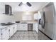 Modern kitchen featuring white cabinets, stainless steel appliances, and stylish patterned flooring, perfect for cooking at 7817 Aplin Ave, Las Vegas, NV 89145