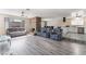 Open-concept living area featuring modern flooring, a stone fireplace, and seamless access to the kitchen at 7817 Aplin Ave, Las Vegas, NV 89145