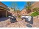 Beautiful backyard with a stone fire pit, outdoor seating, lush landscaping, and privacy wall at 8 Via Dolcetto, Henderson, NV 89011