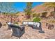 Inviting backyard with a charming curved sofa around a stone fire pit, perfect for relaxation and gatherings at 8 Via Dolcetto, Henderson, NV 89011