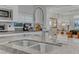 Close up of bright kitchen boasts granite counters, stainless steel sink, modern faucet, and stainless appliances at 8 Via Dolcetto, Henderson, NV 89011