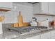 Kitchen features granite counters, white tile backsplash, white cabinetry, and stainless steel gas cooktop at 8 Via Dolcetto, Henderson, NV 89011