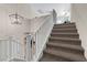 Carpeted staircase with white railing and modern light fixture at 8 Via Dolcetto, Henderson, NV 89011