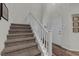 Carpeted staircase with white railing leads to upper level at 8 Via Dolcetto, Henderson, NV 89011