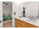 Bright bathroom with double sinks and wooden cabinets, connected to the bedroom via a doorway at 803 Bolide St, Las Vegas, NV 89138