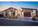 Contemporary home with stone and wood accents, a modern garage door, and desert landscaping at 803 Bolide St, Las Vegas, NV 89138