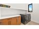 Well-equipped laundry room with modern washer and dryer, storage cabinets, and ample countertop space at 803 Bolide St, Las Vegas, NV 89138