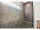 Modern shower with large gray tiles, a built-in bench, and a convenient shower niche at 803 Bolide St, Las Vegas, NV 89138