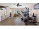 Bright home gym with an elliptical machine, TV, shelving, and multiple windows at 820 Sandhill Sage St, Henderson, NV 89052