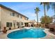 Outdoor view features a sparkling pool, covered patio, and lush greenery, creating a private oasis at 820 Sandhill Sage St, Henderson, NV 89052