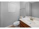 A half bathroom featuring a wood cabinet, sink, mirror, and a window with blinds at 8620 Abbey Dell Ave, Las Vegas, NV 89178