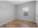 This bedroom features wood flooring, base trim and a window with blinds at 8620 Abbey Dell Ave, Las Vegas, NV 89178