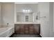 Spacious bathroom with double sinks, dark cabinets, a soaking tub, and modern finishes at 8754 Moon Crater Ave, Las Vegas, NV 89178