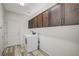 Laundry room with wood-look floors, storage cabinets, and modern washer and dryer at 8754 Moon Crater Ave, Las Vegas, NV 89178