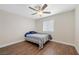 Bright bedroom features wood floors, a ceiling fan, and a window with a view of the surrounding area at 8912 Dio Guardi Dr, Las Vegas, NV 89117