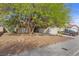 View of a home featuring mature trees, a spacious front yard with desert landscaping, and a two-car garage at 8912 Dio Guardi Dr, Las Vegas, NV 89117