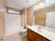 Bright bathroom with a shower-tub combo, wood vanity, and white countertop at 8149 Sandy Slope Ct, Las Vegas, NV 89113