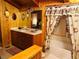 Cozy bathroom featuring wood paneling, double sink vanity, and tub/shower combo with floral shower curtain at , Mount Charleston, NV 89124