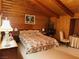 Bedroom with warm wood paneled walls, a patterned bedspread, and a vintage nightstand at , Mount Charleston, NV 89124