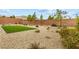 View of the spacious backyard with gravel, desert landscaping, block wall and artificial turf at 10016 Copper Edge Rd, Las Vegas, NV 89148