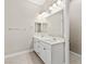 Bright bathroom with double vanity, white cabinets, and tile flooring at 10016 Copper Edge Rd, Las Vegas, NV 89148