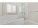 Bathroom featuring a standalone tub, glass-enclosed shower, and window with white shutters at 10016 Copper Edge Rd, Las Vegas, NV 89148