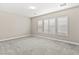 Spacious bedroom featuring plush gray carpeting, neutral walls, and shuttered windows for optimal light control at 10016 Copper Edge Rd, Las Vegas, NV 89148
