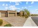 Paver driveway leads to a stylish modern home with a three-car garage and manicured desert landscaping at 10016 Copper Edge Rd, Las Vegas, NV 89148