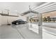 Spacious garage with epoxy flooring, overhead racks for storage, and a black sports car at 10016 Copper Edge Rd, Las Vegas, NV 89148
