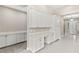 Hallway with white cabinets, desk area, beige walls and tile flooring, leading to the home's entrance at 10016 Copper Edge Rd, Las Vegas, NV 89148